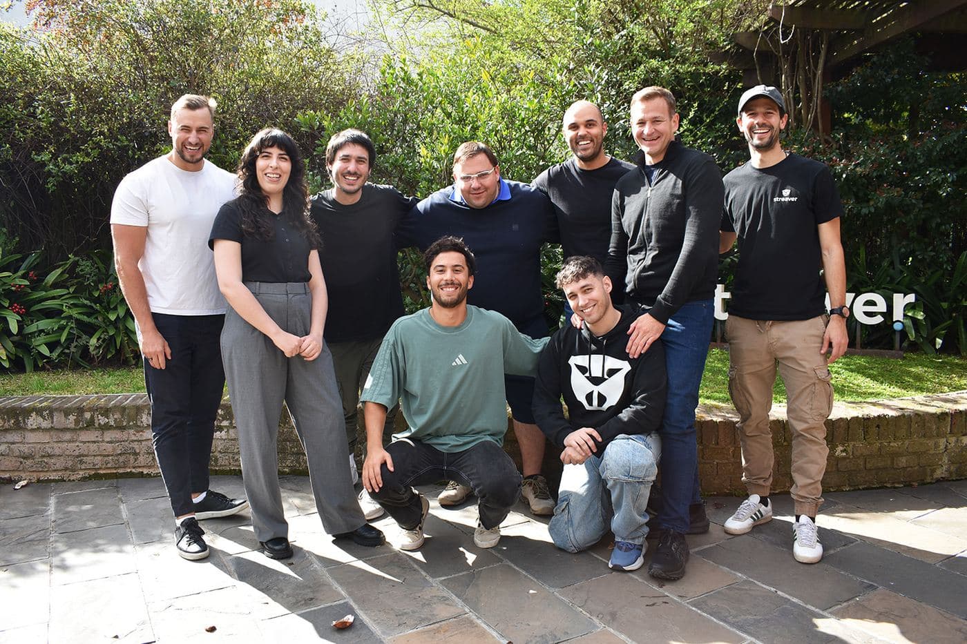 Teammates and visiting clients gathered outside the office by the Streaver sign