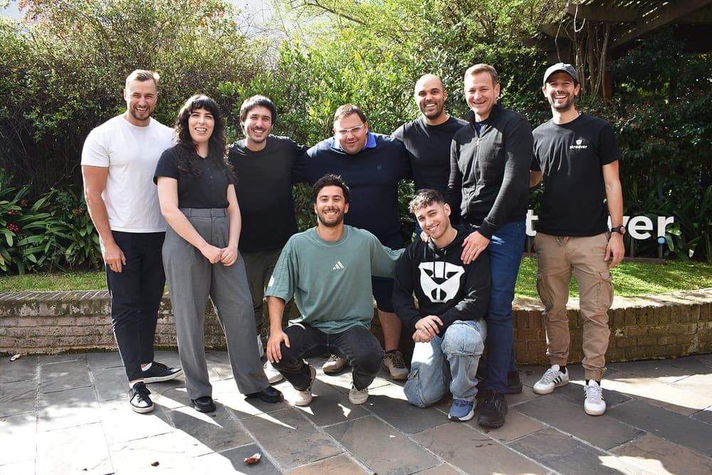 Teammates and visiting clients gathered outside the office by the Streaver sign