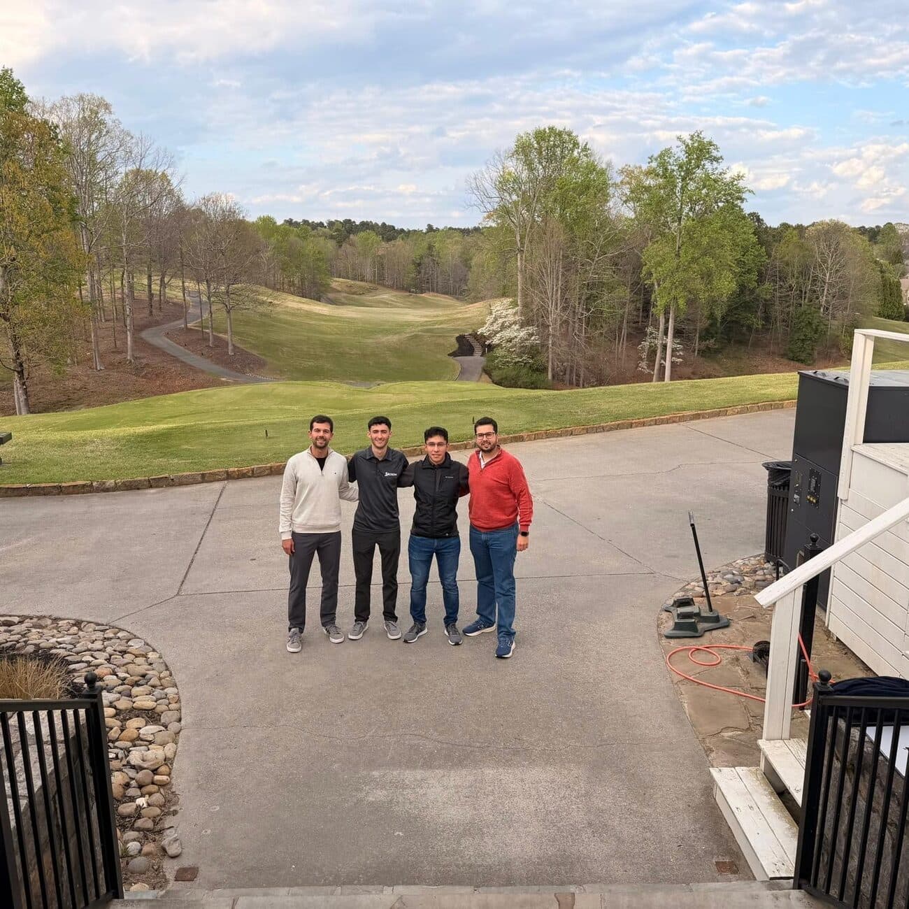Four Streaver team members standing together on the cart path with the golf course behind them.